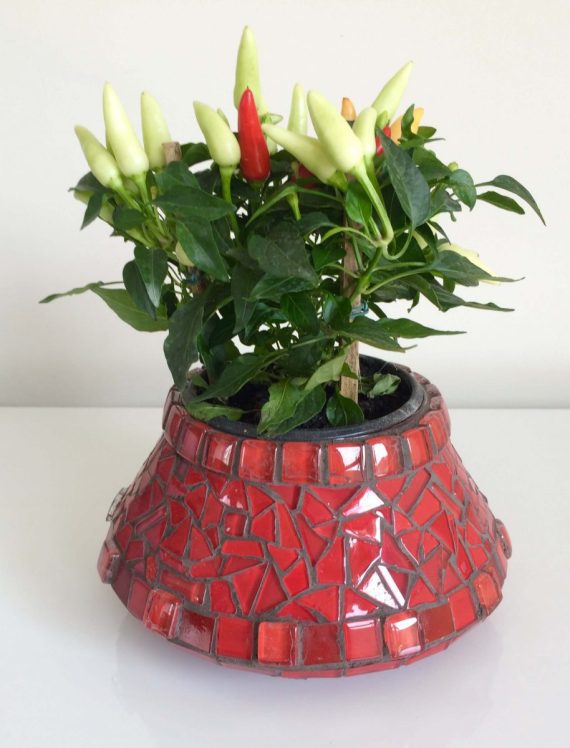 Cachepô em mosaico de vidro vermelho.